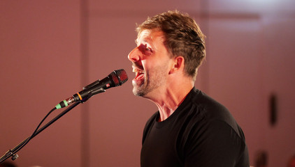 Chorleiter Sören Schröder beim Singen am Mikrofon auf der Bühne beim Konzert des Albertinen Mitarbeitenden Gospelchors in der Kirche am Albertinen Krankenhaus in Hamburg. 
