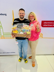 Übergabe des Präsentkorbs an den Gewinner des Pflegequiz am Messestand des Albertinen Krankenhauses Übergabe des Präsentkorbs an den Gewinner des Pflegequiz am Messestand des Albertinen Krankenhauses