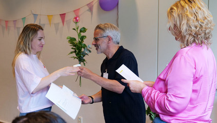 Pflegedirektor Alberto Correia übergibt gemeinsam mit Ute Kröplin einer Pflegefachkraft die Anerkennungsurkunde und eine Rose bei der Anerkennungsfeier für internationale Pflegefachkräfte im Albertinen Krankenhaus in Hamburg.