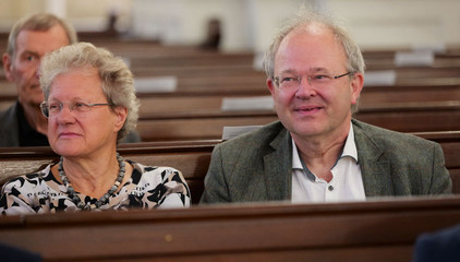Eine Frau und ein Mann sitzen auf einer Kirchenbank im Kirchensaal beim 10. Herzbrücke-Benefizkonzert im Hamburger „Michel“ der Albertinen-Stiftung.