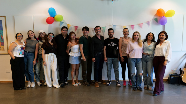 Eine Gruppe internationaler Pflegefachkräfte steht für ein Gruppenfoto zusammen in einem mit Luftballons bunt geschmückten Veranstaltungsraum bei der Anerkennungsfeier für internationale Pflegefachkräfte im Albertinen Krankenhaus in Hamburg.