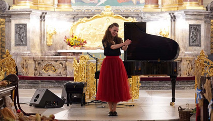 Eine Pianistin klatscht dem Publikum im Kirchensaal zu beim 10. Herzbrücke-Benefizkonzert im Hamburger „Michel“ der Albertinen-Stiftung.