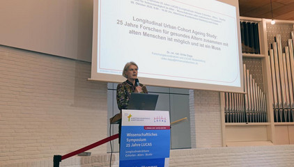 Studienleiterin Dr. Ulrike Dapp steht am Rednerpult vor einer Projektionsleinwand bei der Jubiläumsveranstaltung mit Symposium und einer Dankesveranstaltung zum 25-jährige Bestehen der LUCAS Langzeit-Kohortenstudie im Hamburger Albertinen Haus und Kirche am Albertinen Krankenhaus.