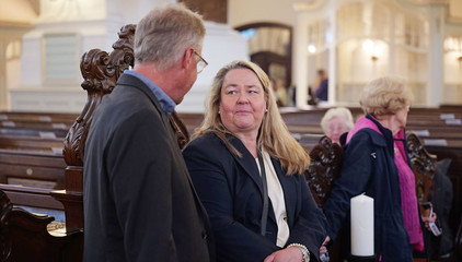 Andrea Wichmann, Konzergeschäftsführerin Immanuel Albertinen Diakonie, unterhält sich mit einem Gast im festlichen Kirchensaal beim 10. Herzbrücke-Benefizkonzert im Hamburger „Michel“ der Albertinen-Stiftung.