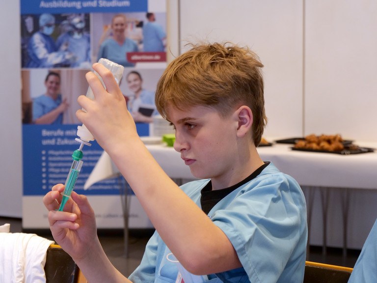 Schüler am Tisch bei der Befüllung eines Infusionskits im Albertinen Krankenhaus beim Girls' und Boys'Day