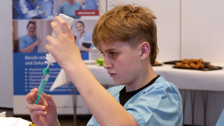 Schüler am Tisch bei der Befüllung eines Infusionskits im Albertinen Krankenhaus beim Girls' und Boys'Day 2025, Schnupperpraktikum Schülerinnen und Schüler, Ausbildung, Karriere, Pflege, Hamburg und Umgebung Schüler am Tisch bei der Befüllung eines Infusionskits im Albertinen Krankenhaus beim Girls' und Boys'Day