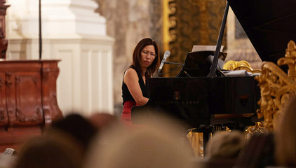 Eine Pianistin spielt am Flügel im festlichen Kirchensaal beim 10. Herzbrücke-Benefizkonzert im Hamburger „Michel“ der Albertinen-Stiftung.