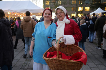 Pflegekraft und Weihnachtsfrau der Immanuel Albertinen Diakonie stehen lächelnd am Abend zusammen Pflegekraft und Weihnachtsfrau der Immanuel Albertinen Diakonie stehen lächelnd am Abend zusammen