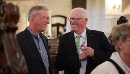 Zwei Gäste unterhalten sich im Kirchensaal beim 10. Herzbrücke-Benefizkonzert im Hamburger „Michel“ der Albertinen-Stiftung.