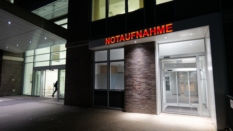 Beleuchteter Eingang der Zentralen Notaufnahme am Albertinen Krankenhaus mit rotem Schriftzug „NOTAUFNAHME“ über den Glastüren.