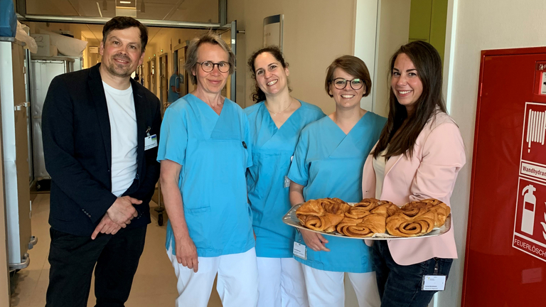 Daniel Centgraf und Darina Bertelmann verteilen am Internationalen Tag der Pflegenden Franzbrötchen auf einer Station im Albertinen Krankenhaus