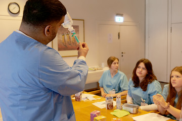 Ein Pfleger zeigt Schülerinnen und Schüler das Befüllen einer Spritze im Albertinen Krankenhaus beim Girls' und Boys'Day 2025